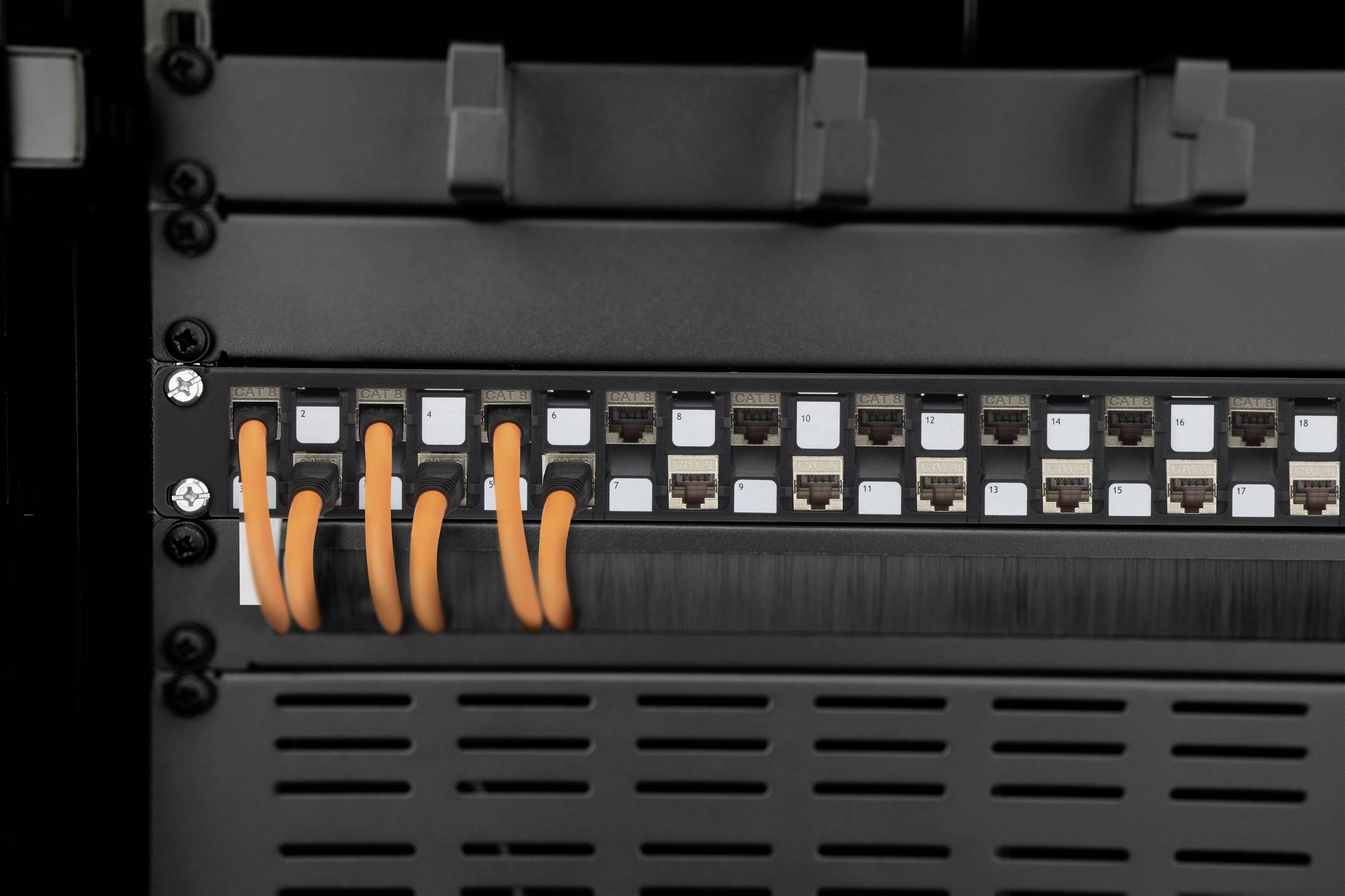 A patch panel with multiple Ethernet ports. Six orange cables are connected to some of the ports.
