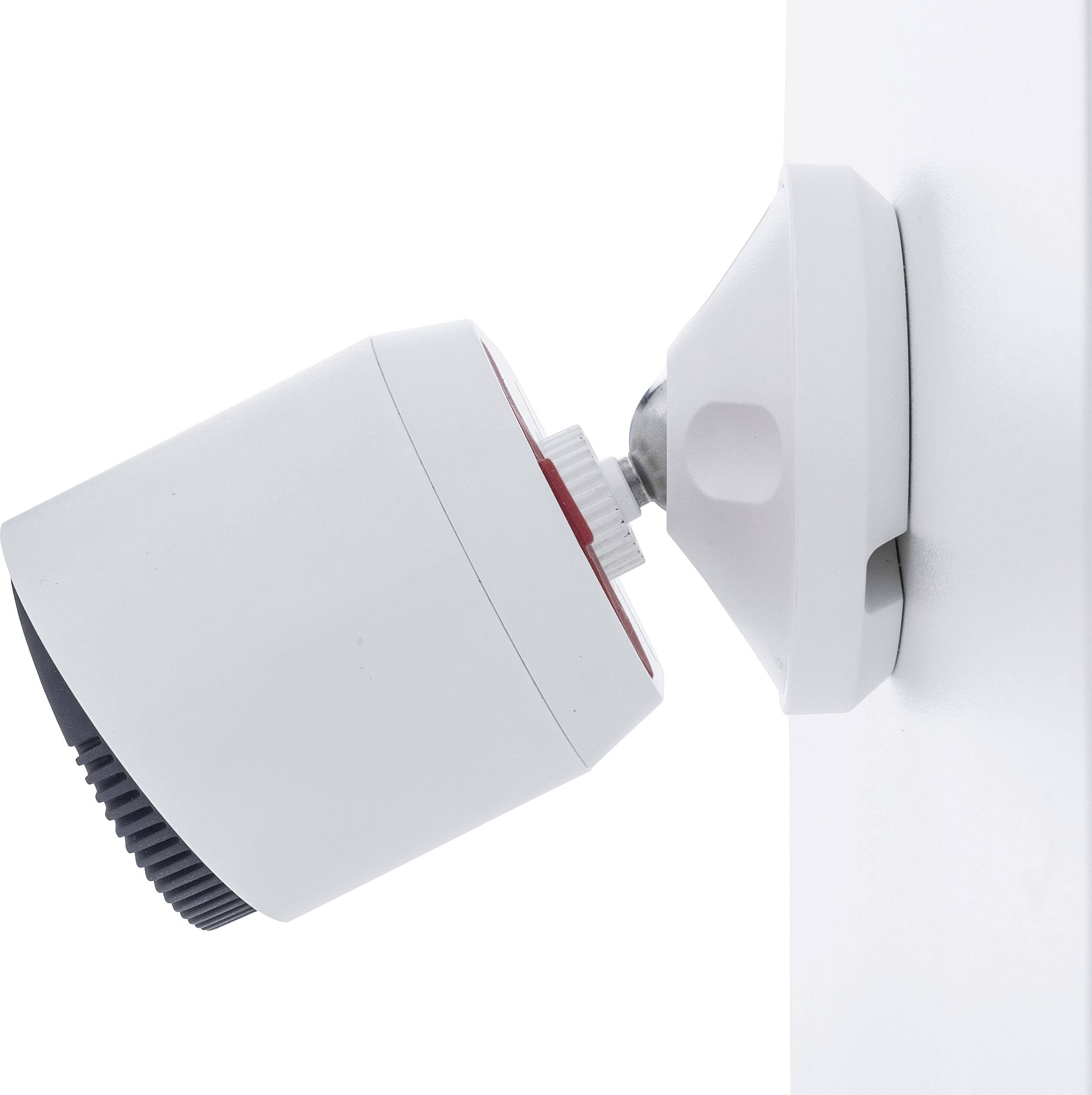 White surveillance camera on a wall mount, for monitoring indoor or outdoor areas.