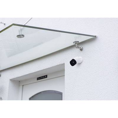 Front door with a security glass canopy and a surveillance camera mounted on the wall.
