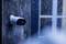 External camera on a house wall, covered in snow, heavy snowfall. Camera monitoring entrance, despite wintry weather.