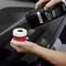 A person is holding a soft polishing pad and applying car polish from a bottle to care for a vehicle's paint surface.