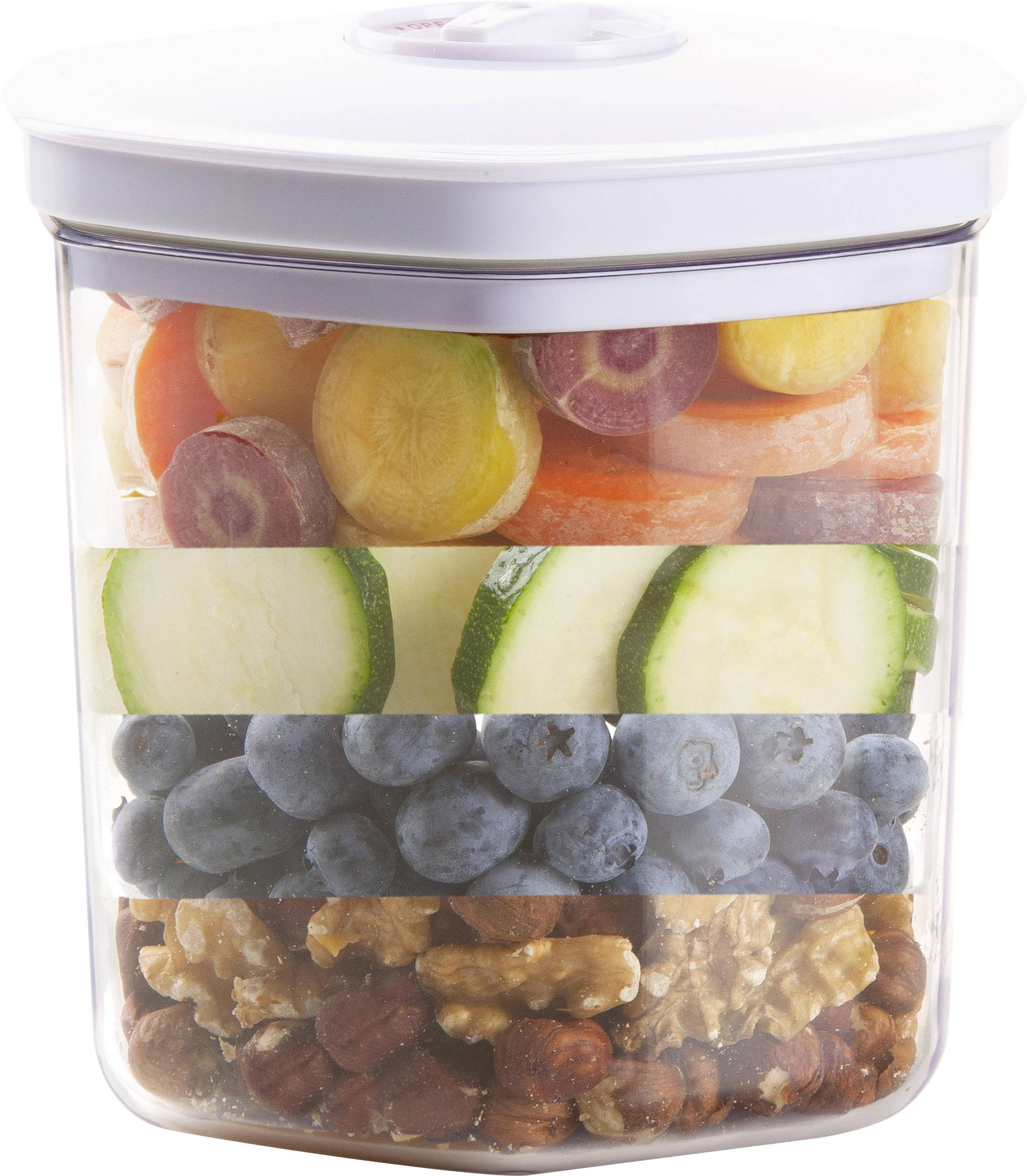 A glass container with a lid shows layers of colourful vegetables and fruit: carrots, courgettes, blueberries, nuts.