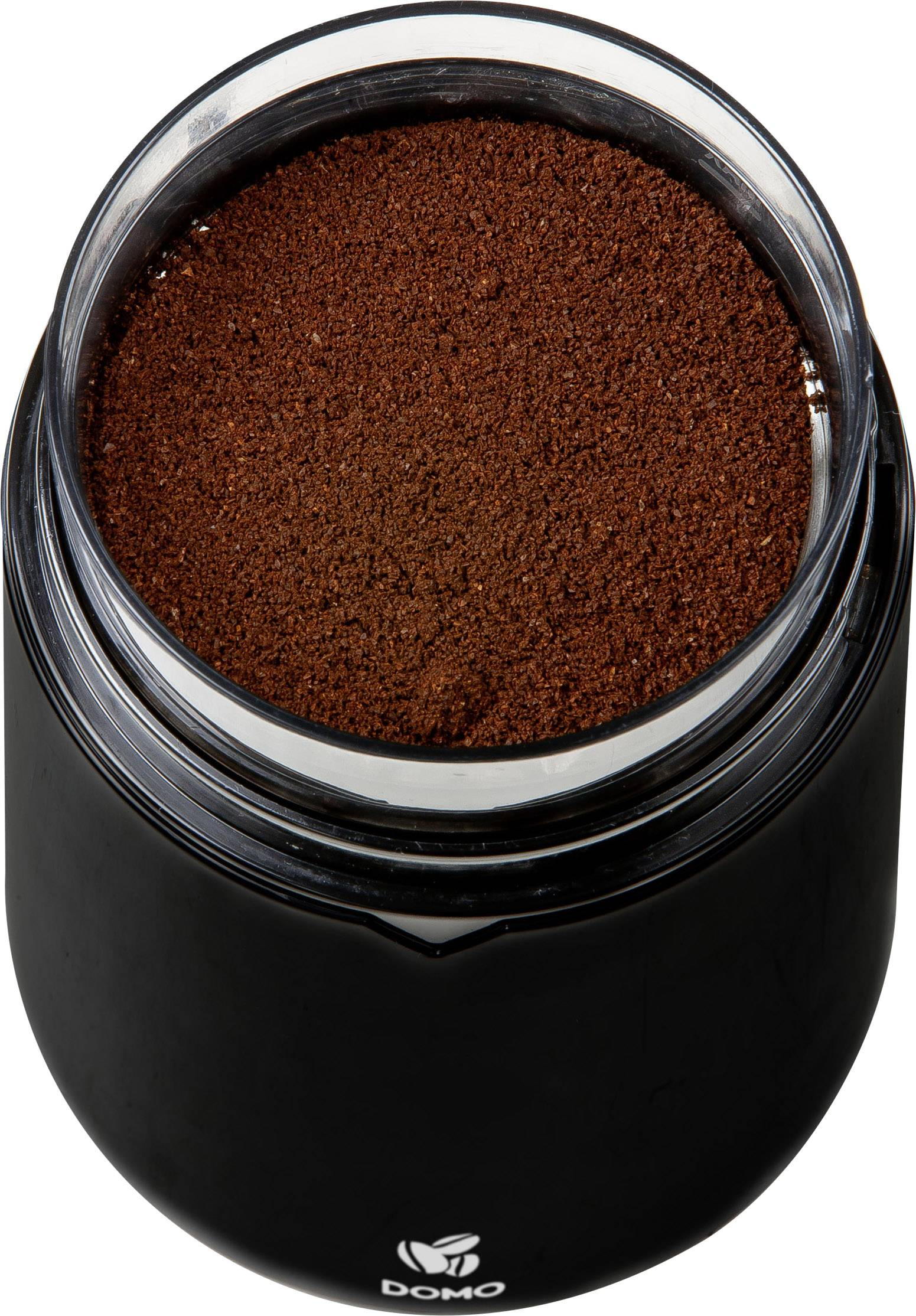 A black tin containing ground coffee, photographed from above. The coffee is finely ground and completely fills the tin.