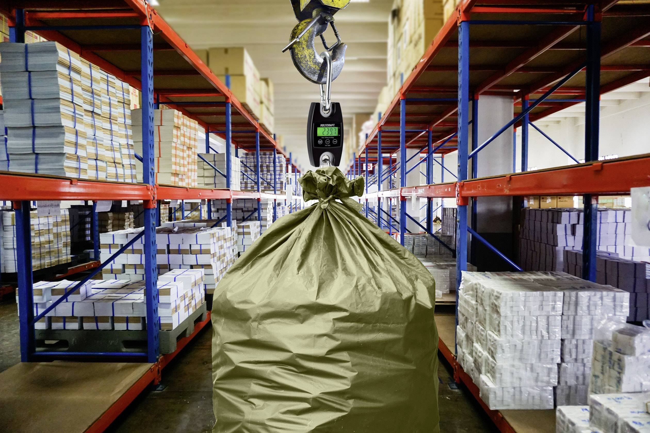 A large sack is being lifted by a hook in a warehouse. Shelves with cardboard boxes are visible in the background.
