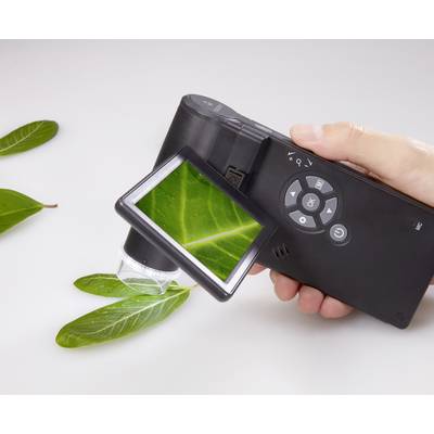 Close-up of a hand holding a digital microscope displaying an enlarged image of a green leaf on the screen.