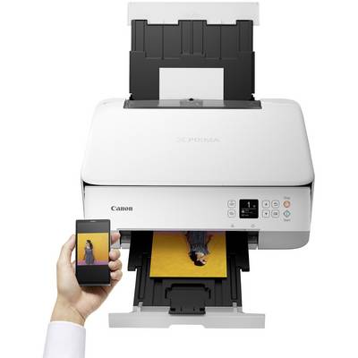 A white Canon printer printing a colour photograph of a person with a yellow background. A smartphone displays the same image.