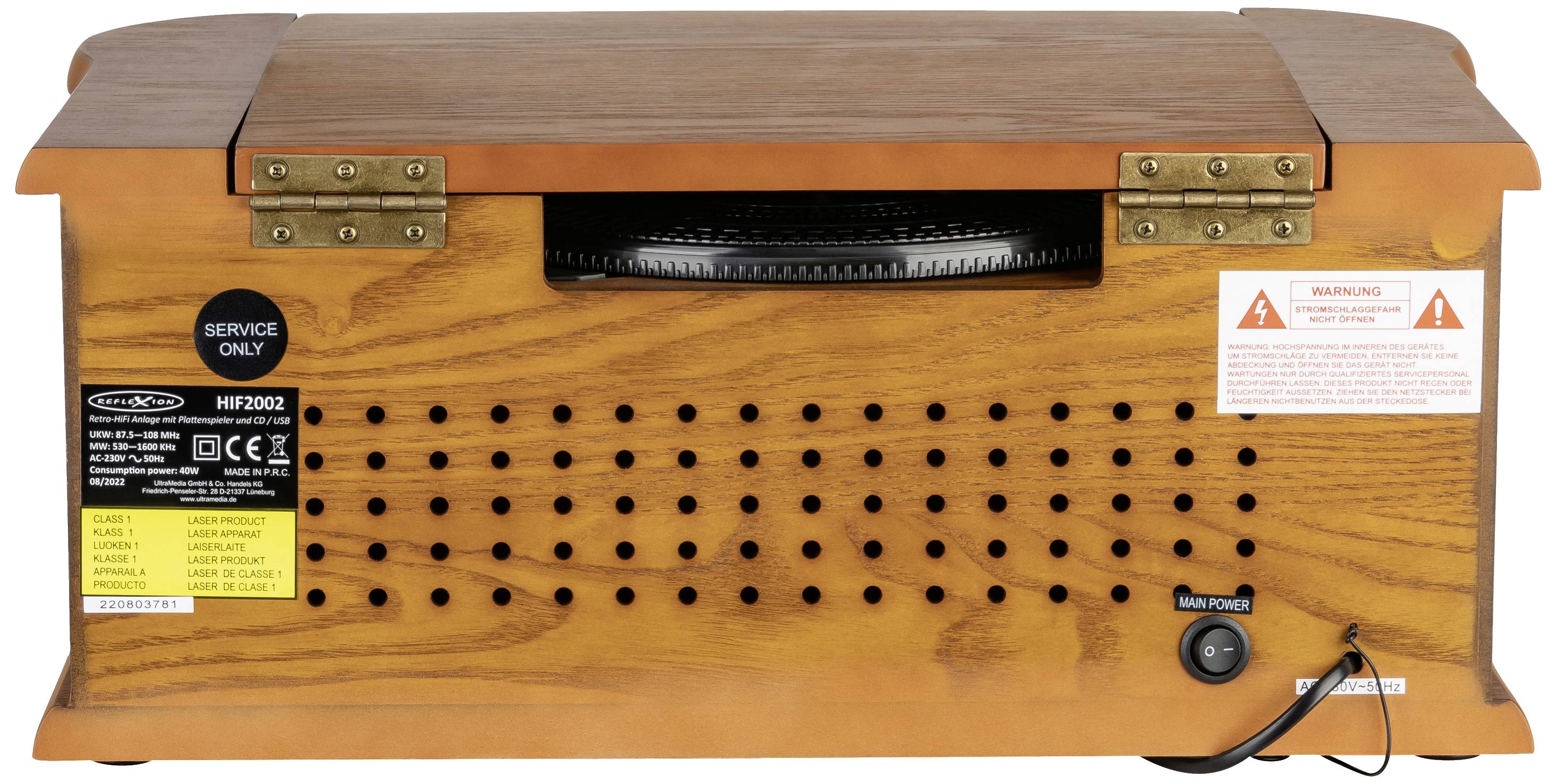 Rear view of a wooden radio with ventilation slots, service sticker, and power connection. Stickers indicate caution.