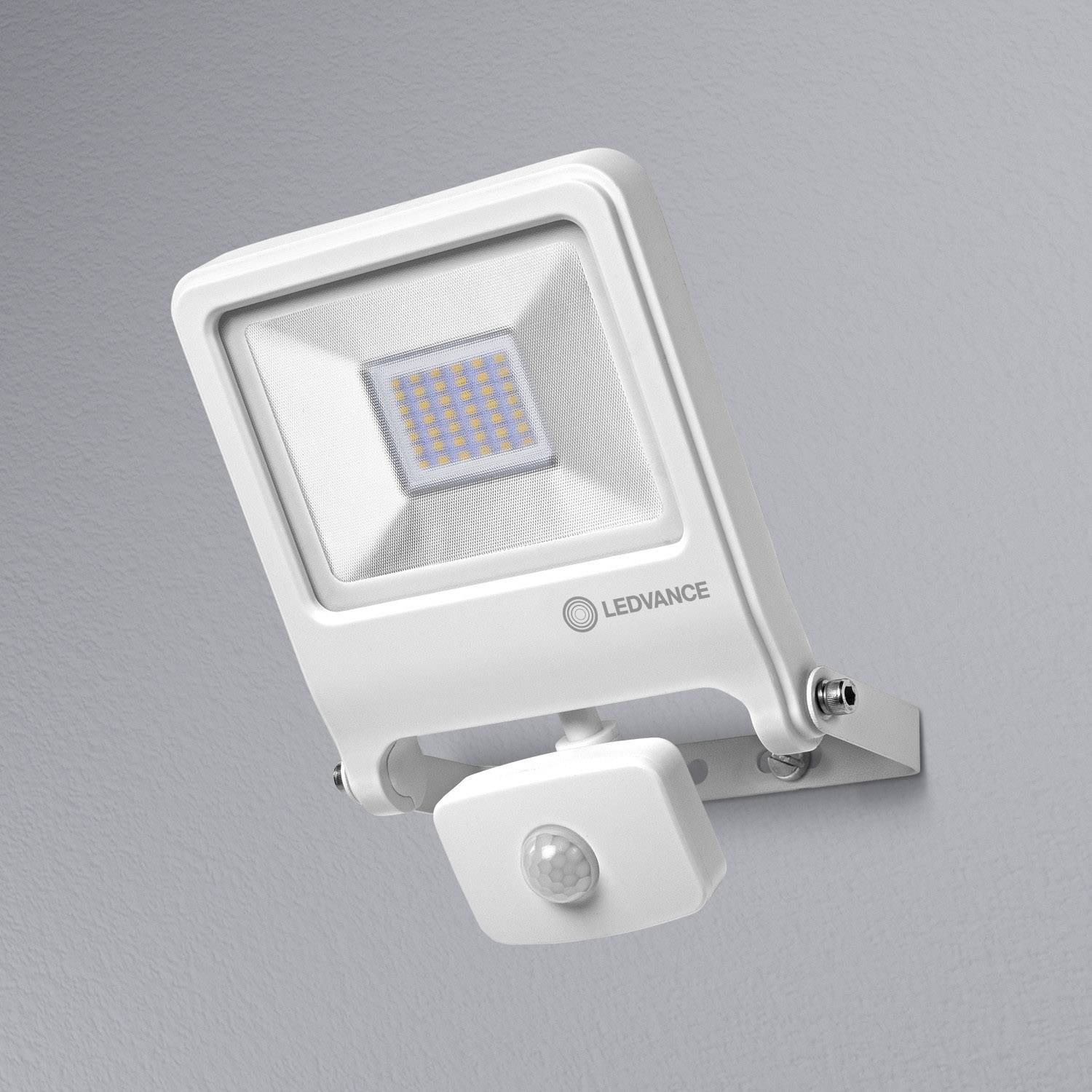 Square LED floodlight mounted on the wall with a motion sensor beneath; white colour, suitable for exterior lighting.