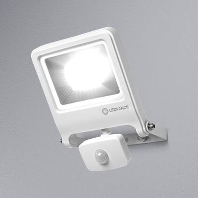 A white LED floodlight with a motion sensor mounted on a grey wall. It emits bright light and features a brand logo.