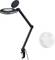 Black desk lamp with articulated arm and round magnifying lens, beside a single clear sphere against a white background.