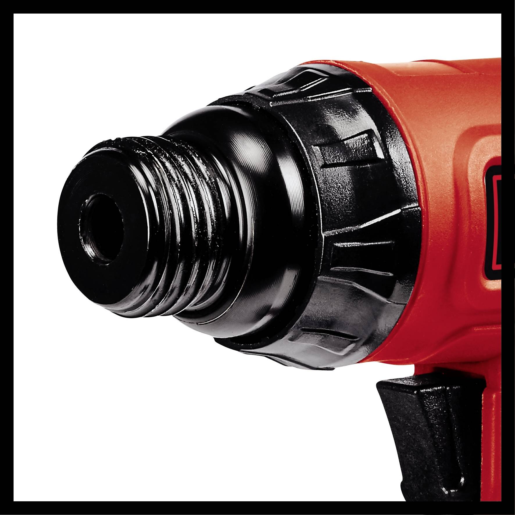 Close-up of a drill chuck on a red drill, showing the internal thread and handle of the tool.