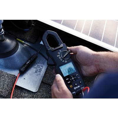 A person is measuring electrical voltage on a solar panel using a digital multimeter. The display shows '0.0003'.