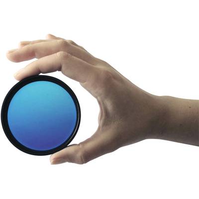 A hand holds a round, blue filter against a white background, which is used for photography or visual effects.