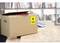 A cardboard box with a yellow 'TOP' sticker sits on a wooden table. A bookshelf is visible in the background.