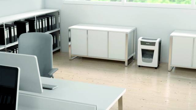 Office with desks, shelves and a shredder on a light wooden floor. Bright, minimalist design.