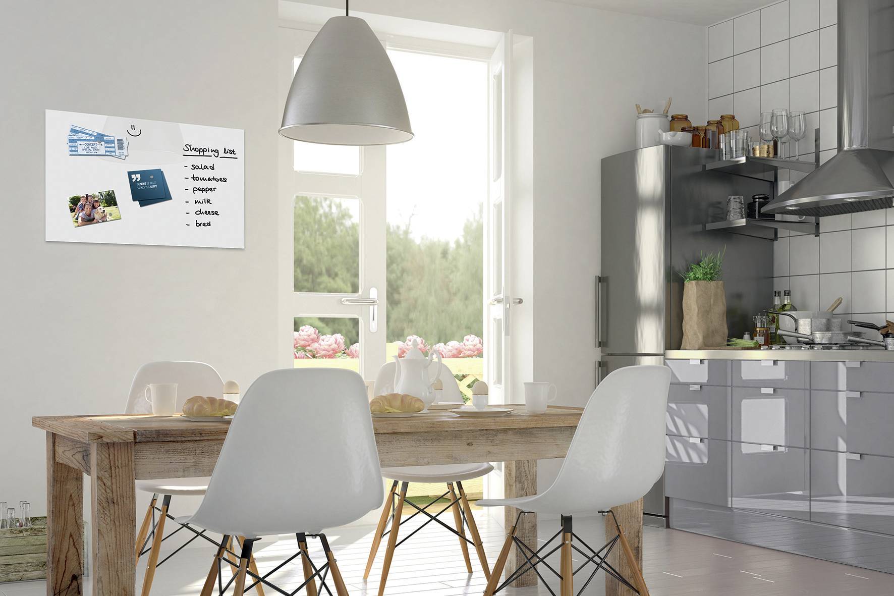 A modern kitchen with a wooden table and four white chairs. A whiteboard on the wall displays a shopping list: 'Bread, milk, eggs, cheese'.
