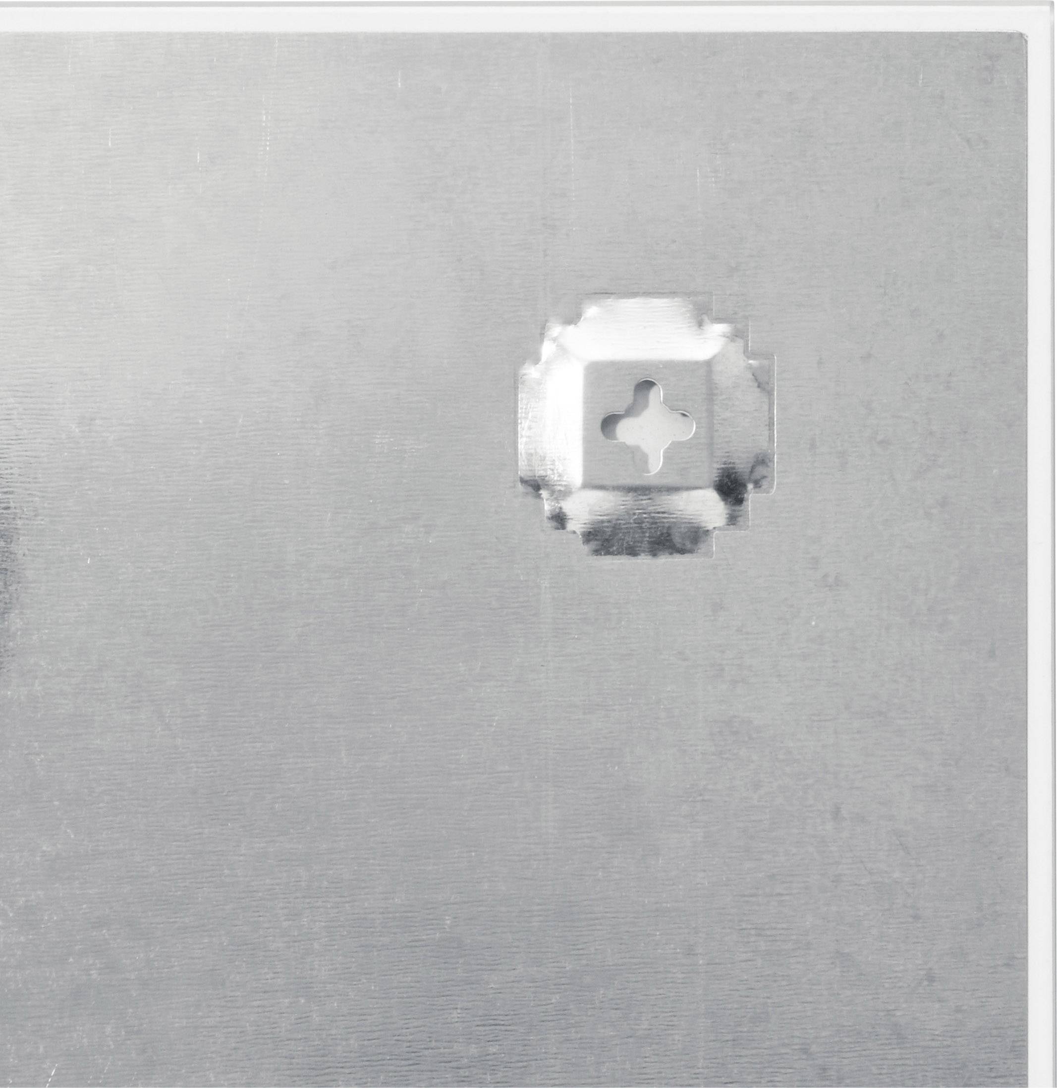 Metal surface with a square indentation and cross pattern on the right side.