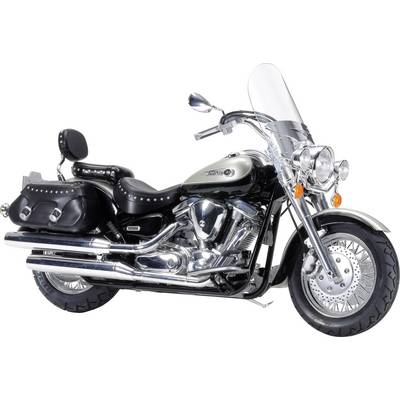 A classic motorcycle with panniers, chrome parts, and a windscreen, stands sideways against a neutral background.