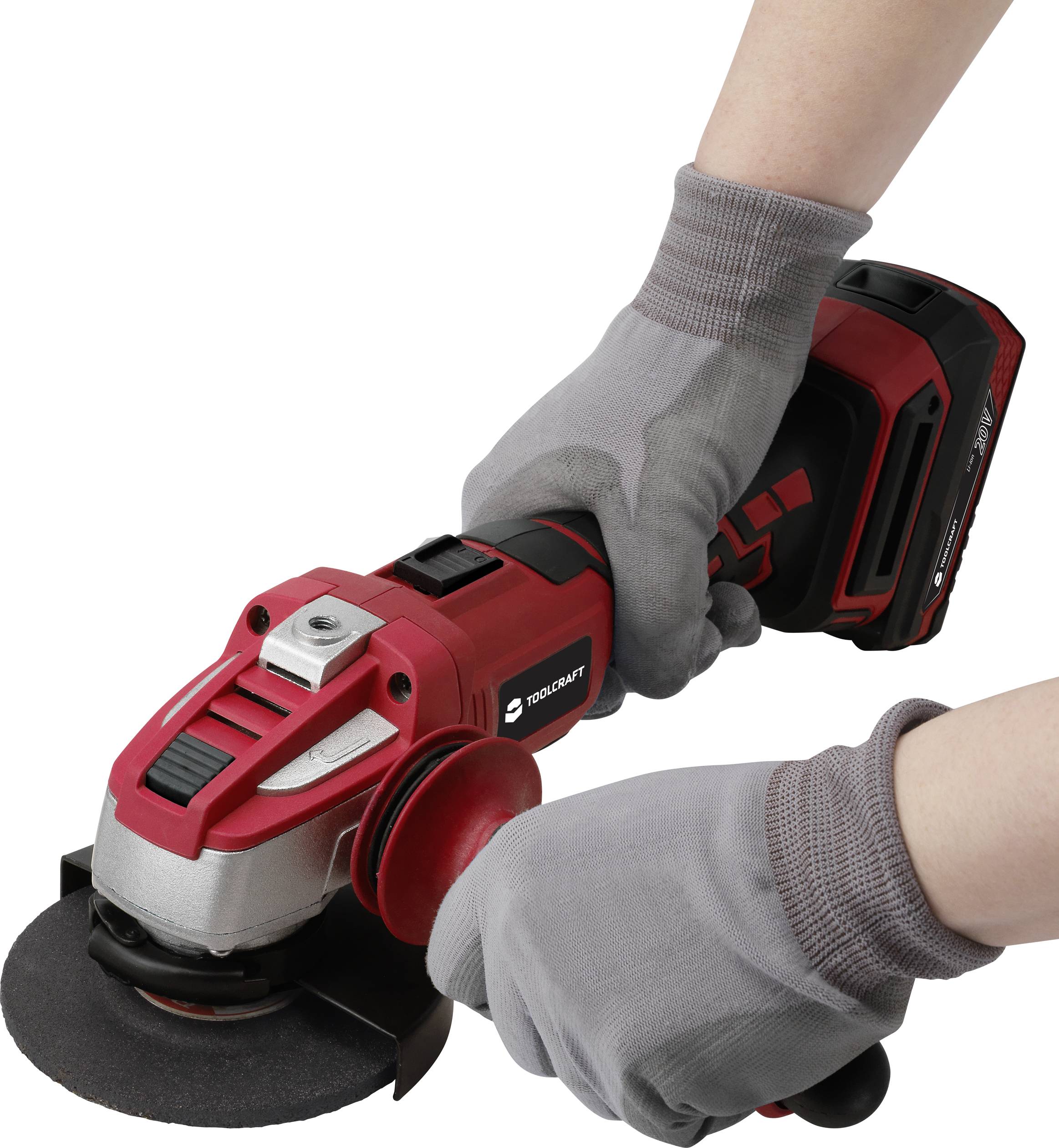 A person is holding a red angle grinder with both hands. The person is wearing grey work gloves.