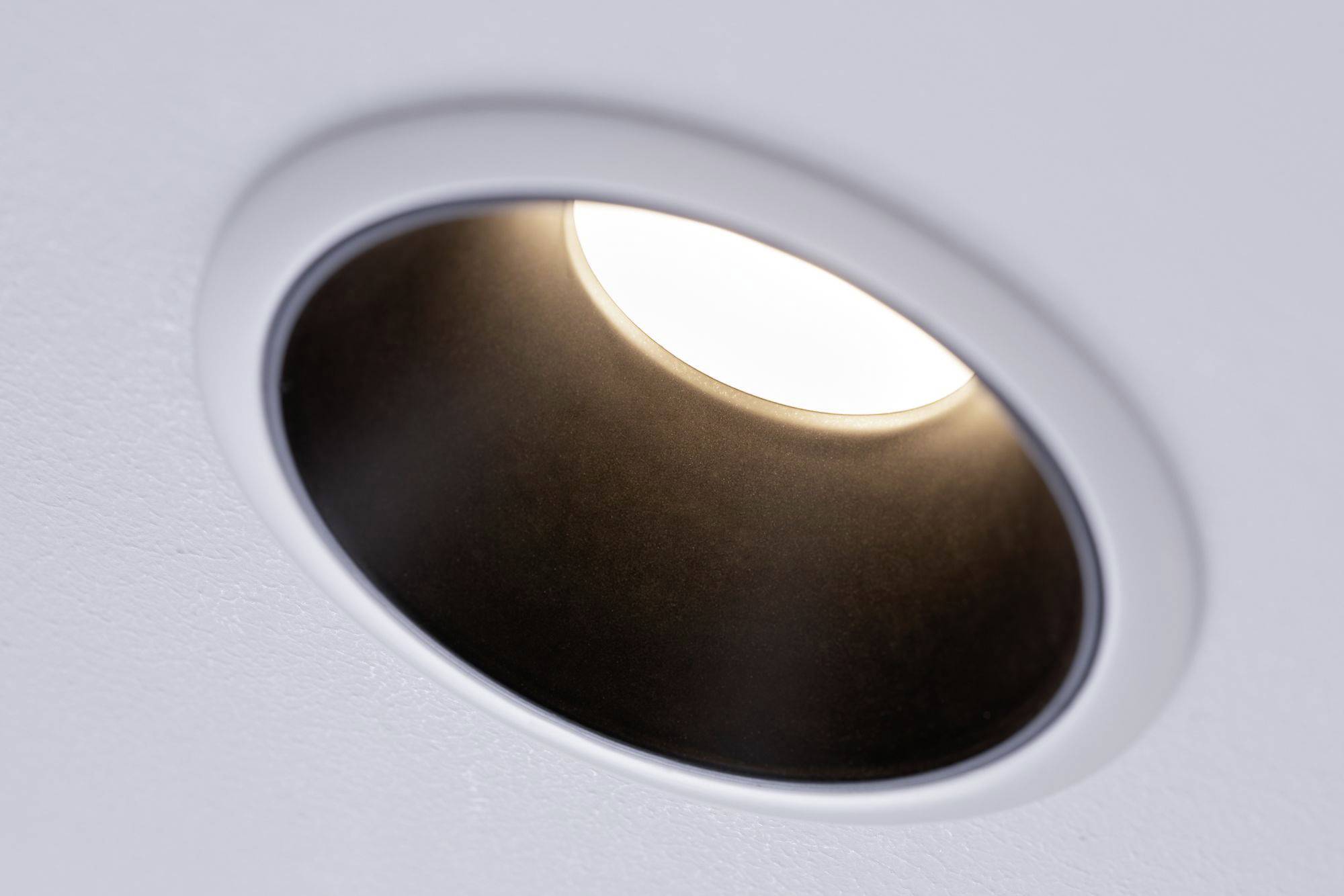 Ceiling spotlight with a round, white frame, emitting warm light.