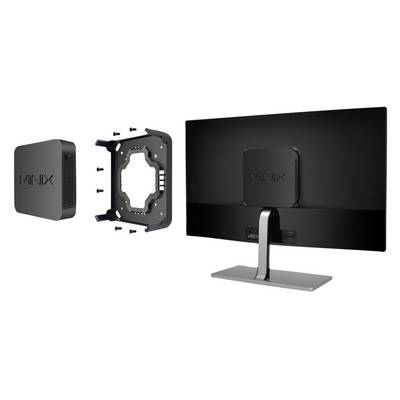 A monitor stands on the right, with a Minix mini PC box and a mounting plate with screws placed beside it on the left.