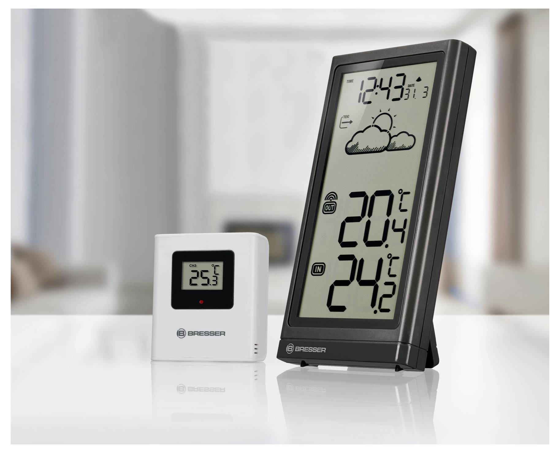 Digital weather station display showing indoor temperature of 20.4°C, outdoor temperature of 24.2°C, and a partly cloudy icon.