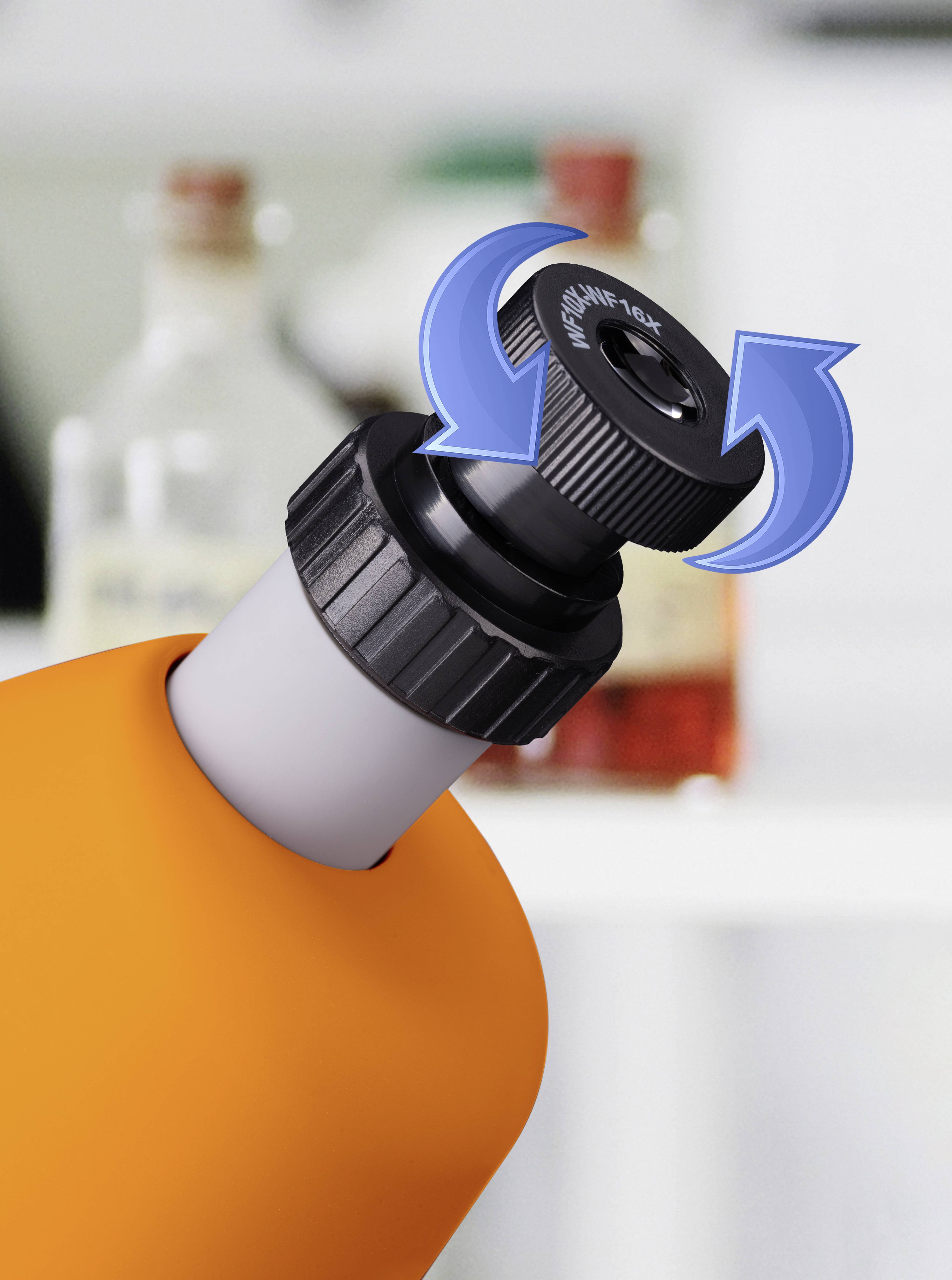 An orange water bottle with a black, rotating lid. Arrows indicate that the lid can be twisted. Blurred bottles in the background.