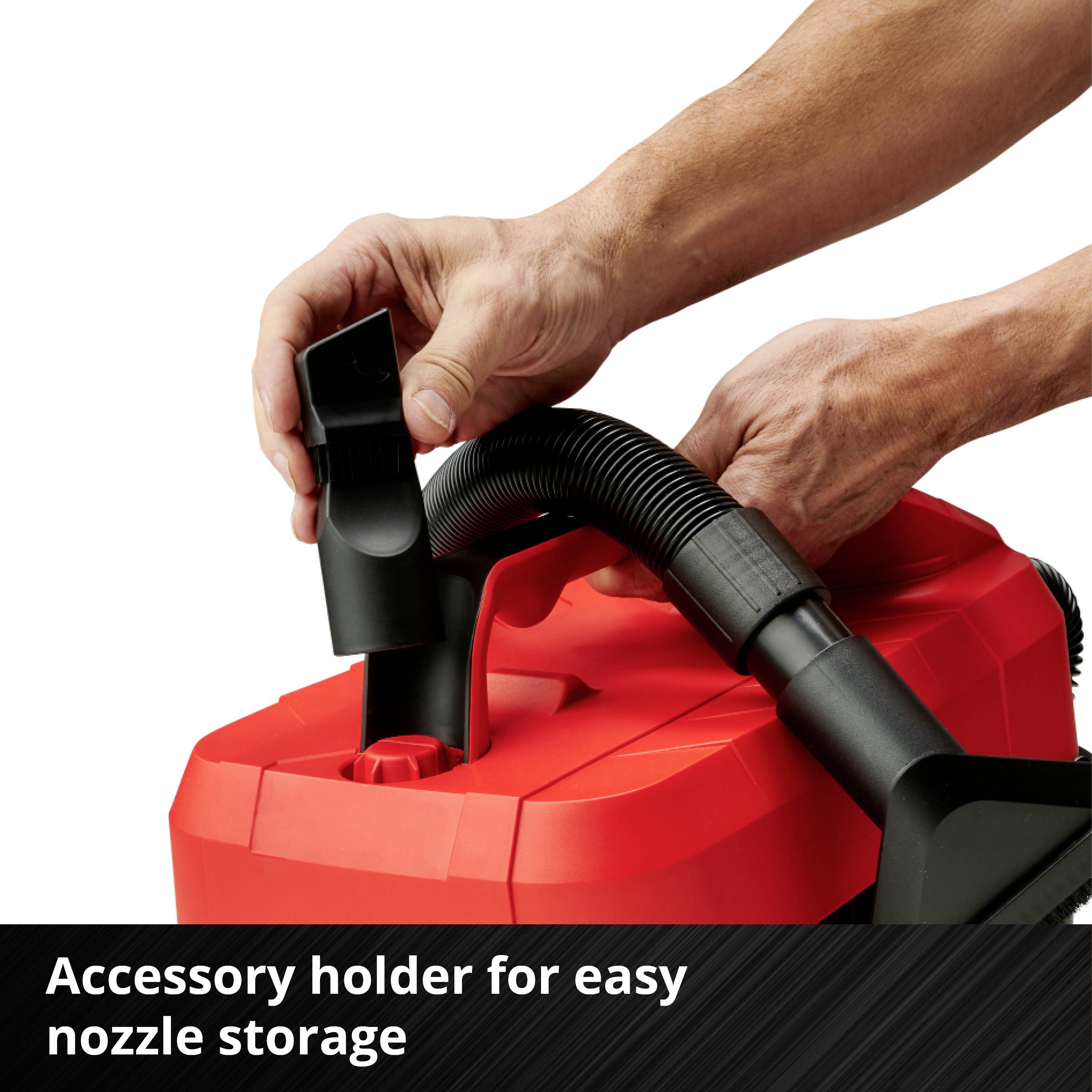Hands are attaching a nozzle to a red vacuum cleaner with the label 'Accessory holder for easy storage of nozzles'.