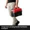 A person is holding a red and black tool case with an integrated handle for easy transport.