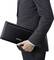 A person in a grey suit is carrying a black Epson printer under their arm.