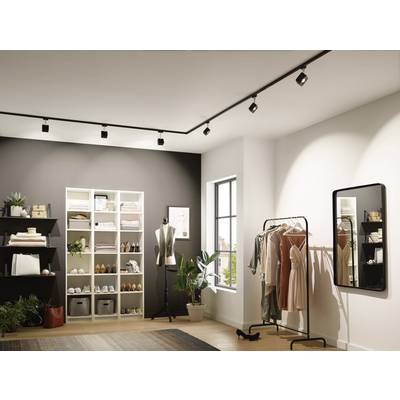 Modern, well-lit room with shelves full of clothing and accessories, a clothes rack with garments, a mirror, and a mannequin.
