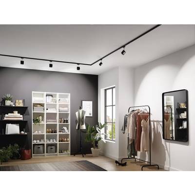 A clothing shop with white shelves displaying clothing and shoes. A clothing rack shows dresses next to a mirror.