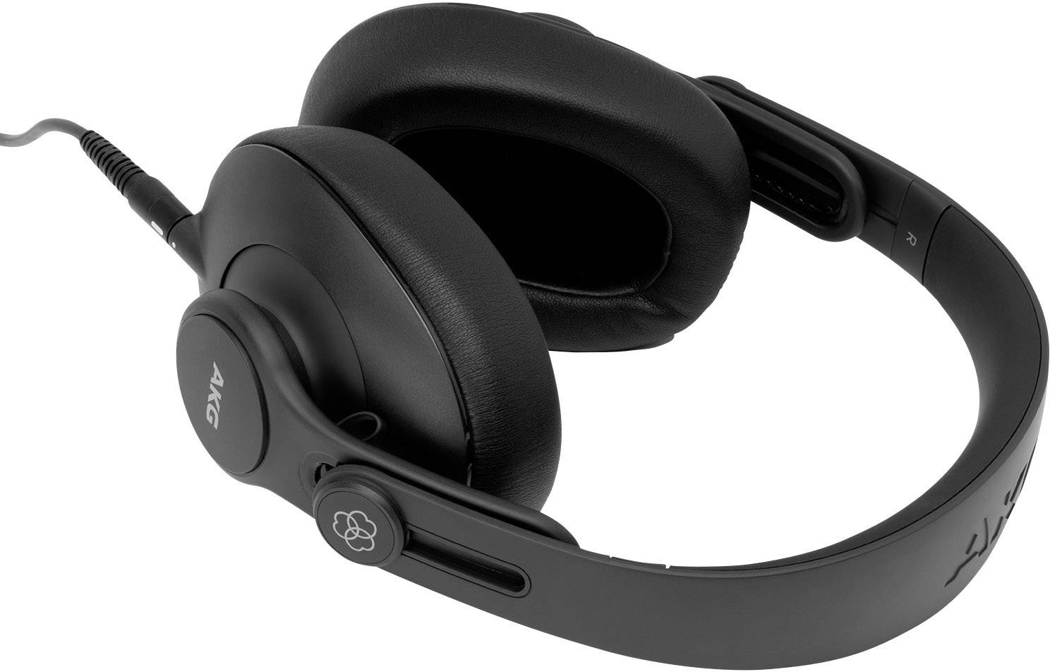Black over-ear headphones with padded ear cups and an adjustable headband are lying on a surface.