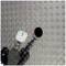 Close-up of a drill with a hole saw attachment drilling a circular hole into a non-slip metal plate.