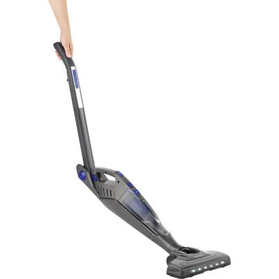 A person is using a cordless, grey vacuum cleaner with LED lights on the head, which is being held upright.