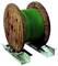 Wooden drum with green cable reel; resting on two metal supports.