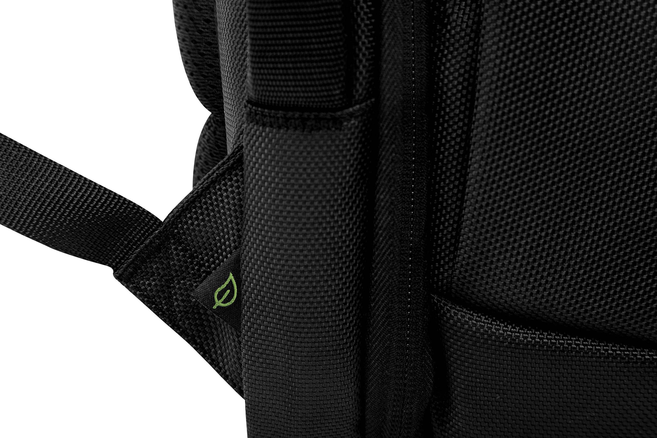 Close-up of a black rucksack, showing the roughly textured material and a small green leaf symbol at the edge.