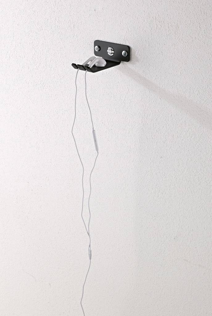 Metal hook on a wall with a hanging, loose wire.