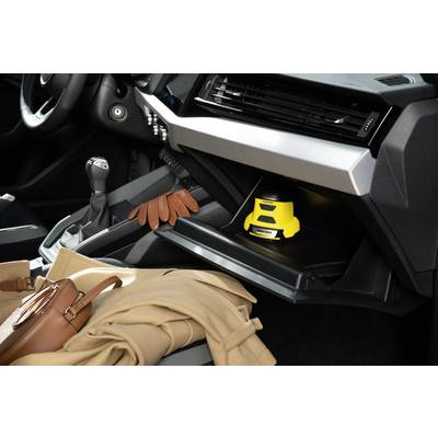 Interior of a car with a yellow laser level device in the glove compartment, brown gloves and coat on the passenger seat.