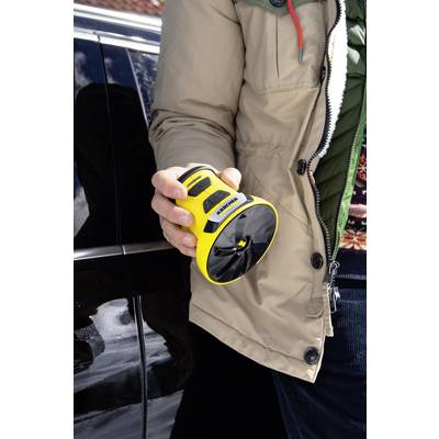 A person is holding a yellow portable device in front of a black car door handle. It appears to be a door opening aid.