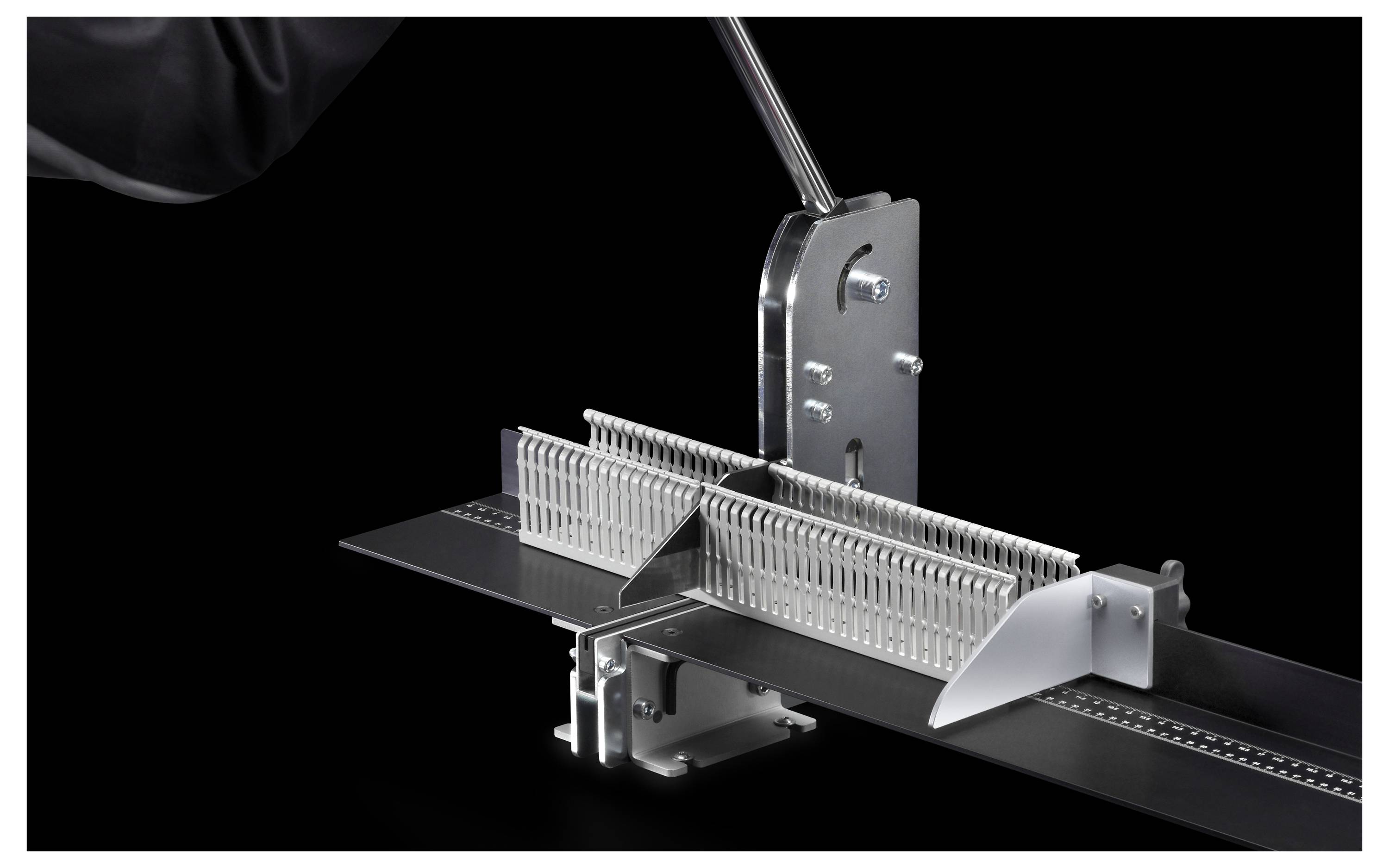 A mechanical cutting device with a lever, suitable for precise material cutting. Black background for focus.