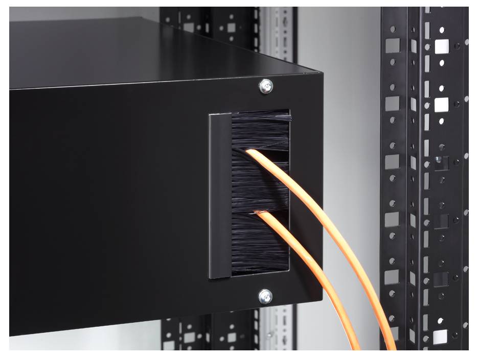 A black server cabinet with two orange cables being routed through an opening. Mounted on a metal frame.