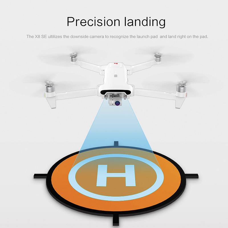 A drone lands precisely on a marked landing pad with the letter 'H'. A blue light beam assists with identification.