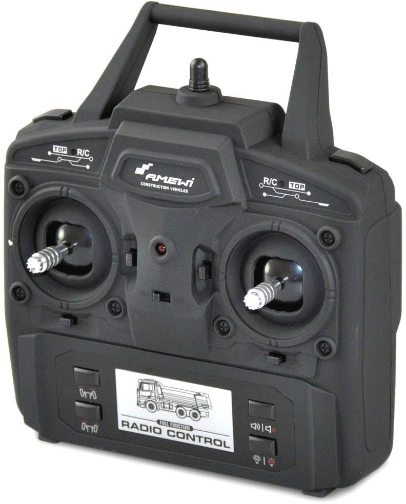 'Black remote control with two joysticks and switches. Label featuring an image of a lorry and the inscription "Radio Control".'