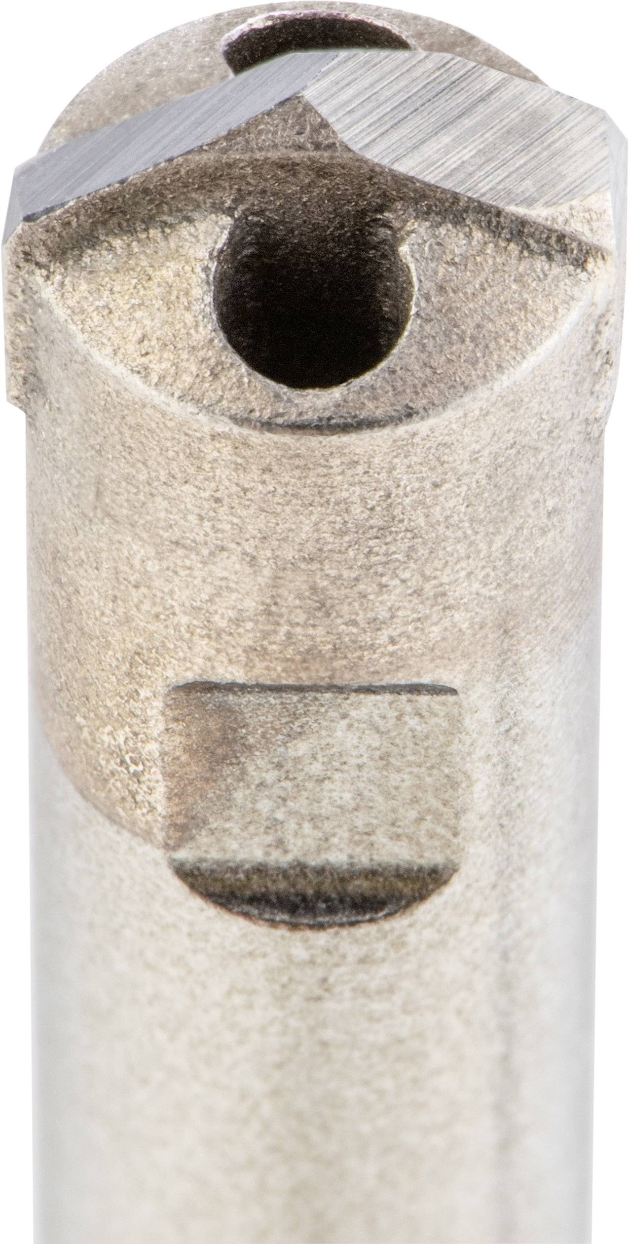 Close-up of a metal cutting tool with a cutting edge and hollow chamber, predominantly in brown and grey tones.