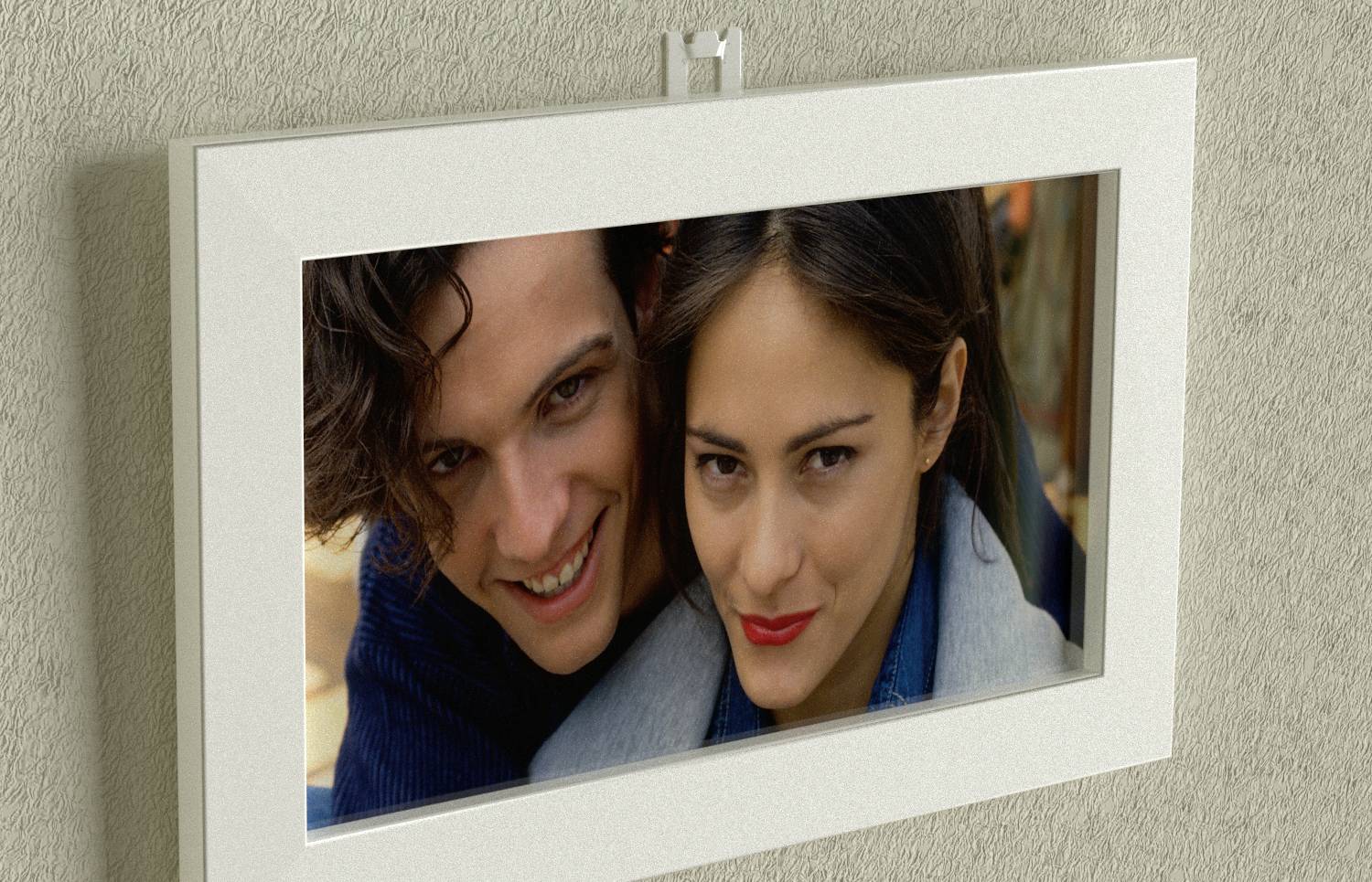 A framed photograph on the wall shows two smiling individuals standing close together.