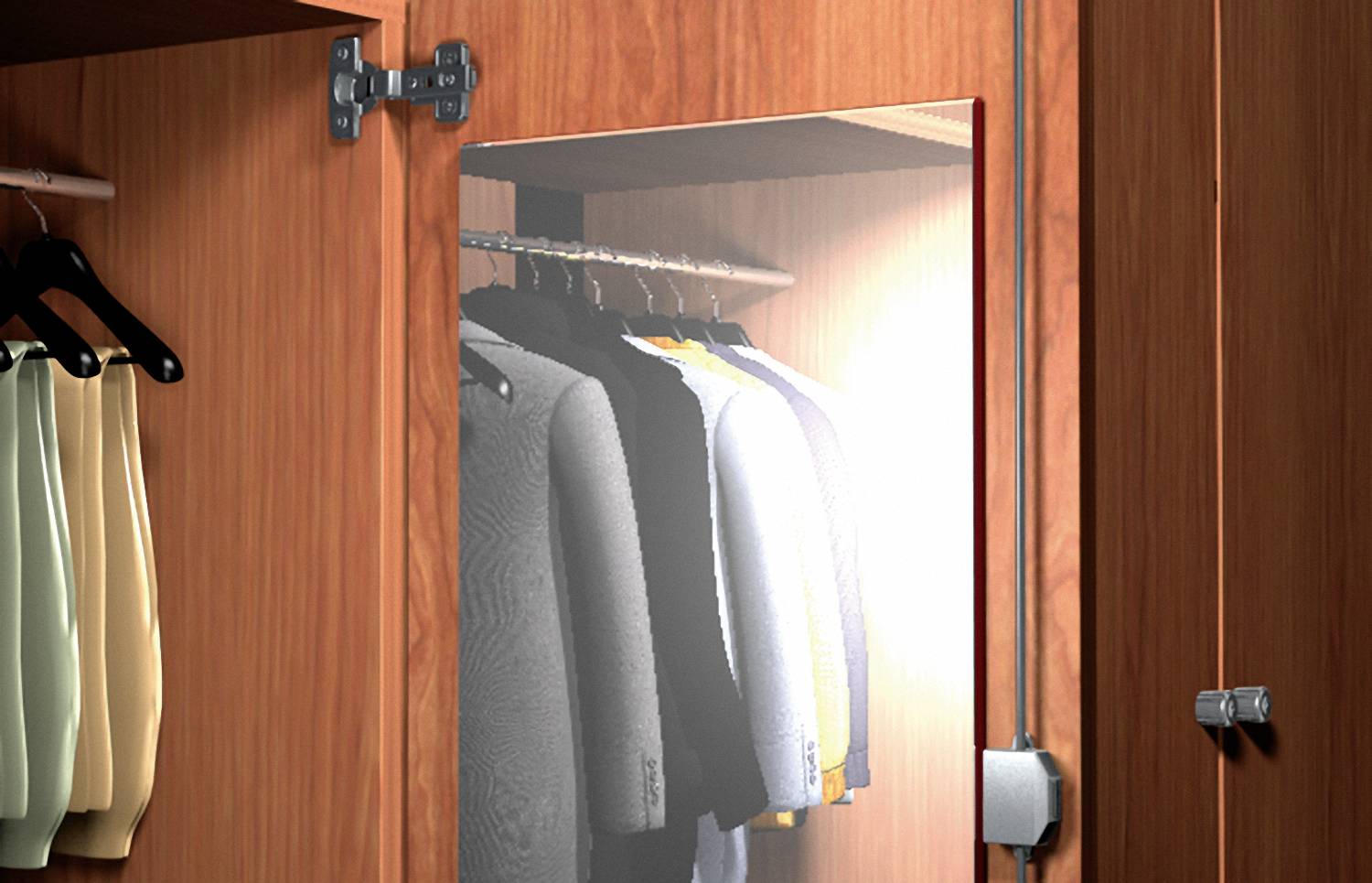 An open wardrobe with several jackets on hangers, with a mirror on the door to the right.