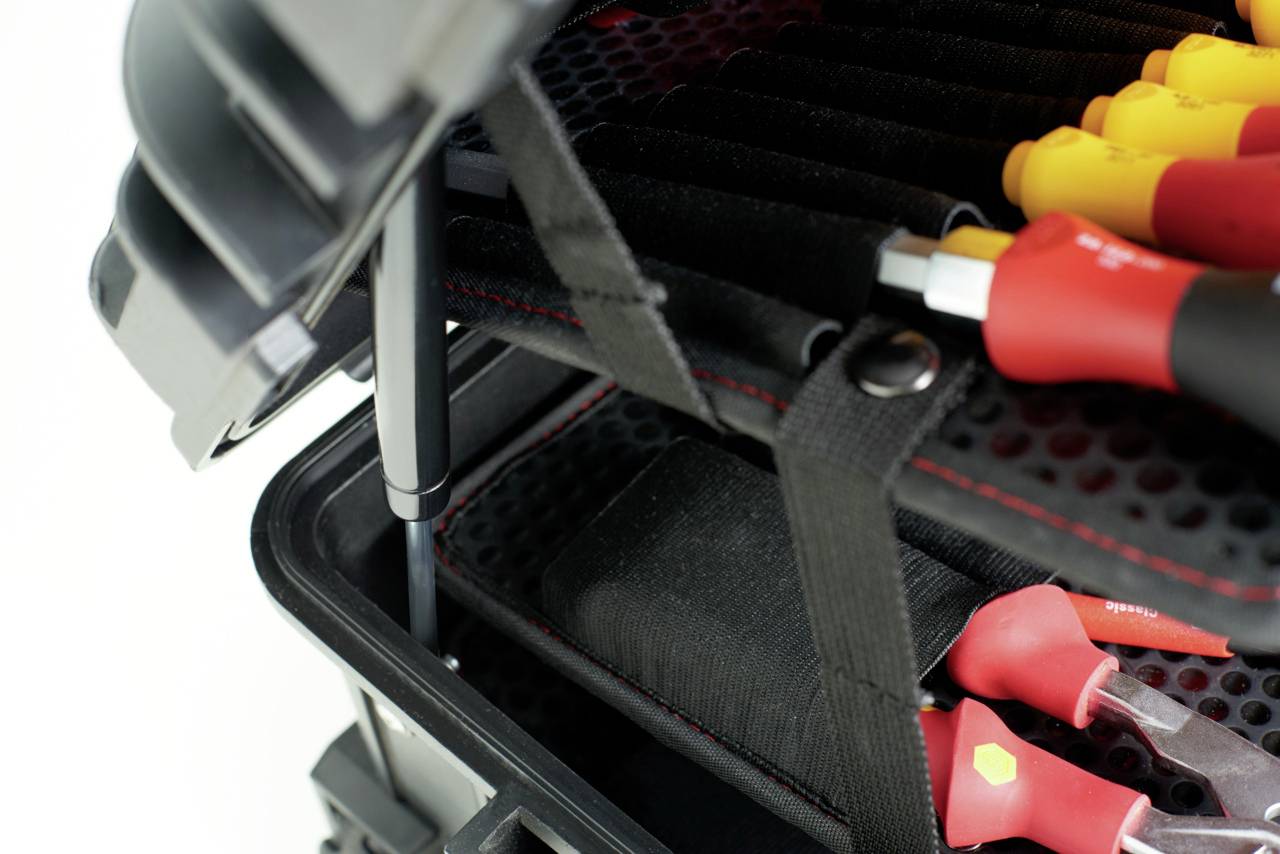 An open toolbox with sorted screwdrivers and loops for securing, against a light background.