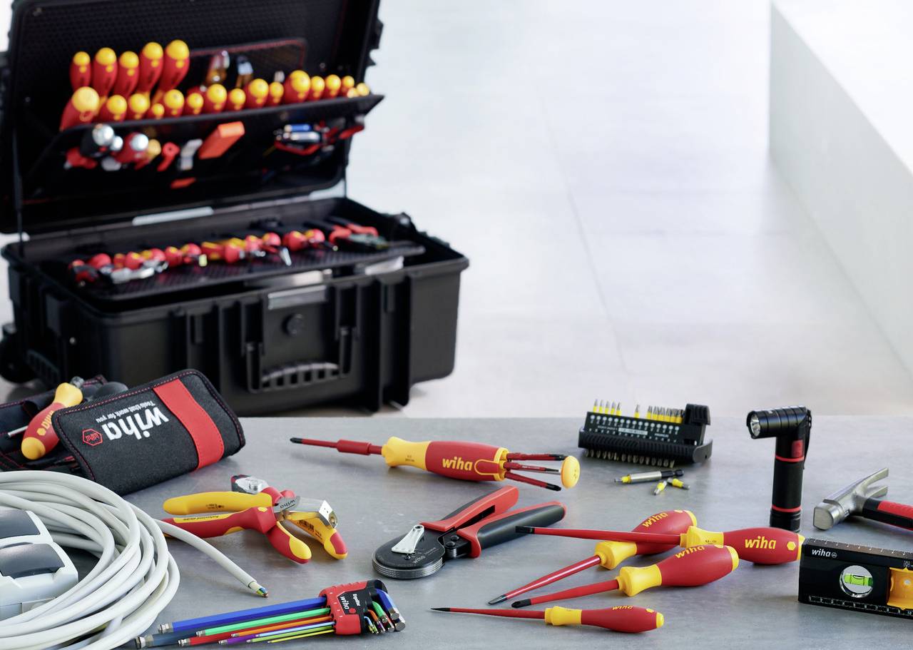 Tool set on a table, including screwdrivers, pliers and measuring device. In the background, an open toolbox.