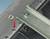 Metal rail and screw on a mounting device, compatible with 'Phoenix Contact'. A red arrow indicates a mounting position.
